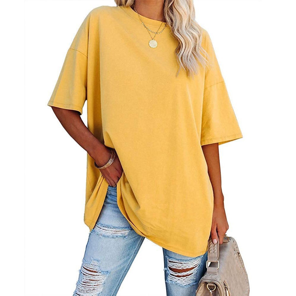 Person wearing a yellow oversized t-shirt and ripped jeans on a white background