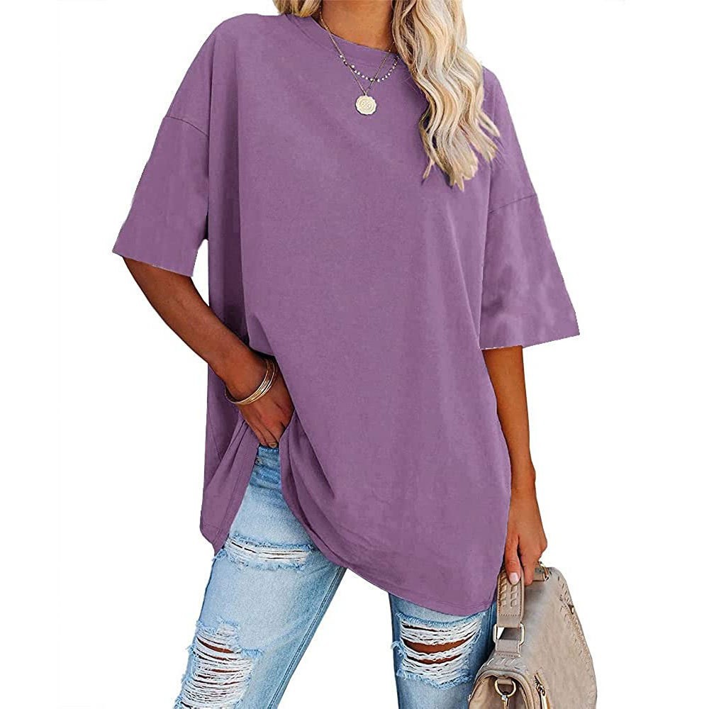 Person wearing a purple oversized t-shirt and ripped jeans on a white background
