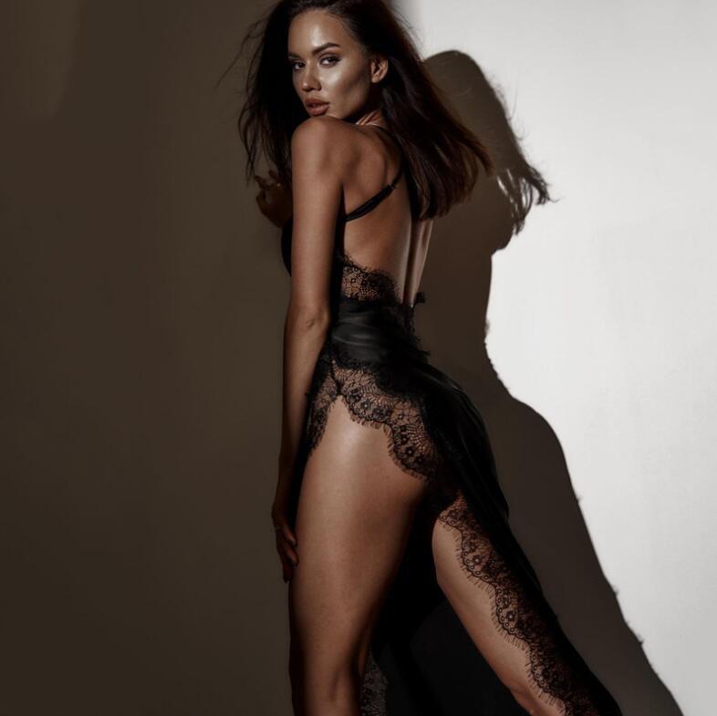 Woman wearing a black lace nightgown against a plain background