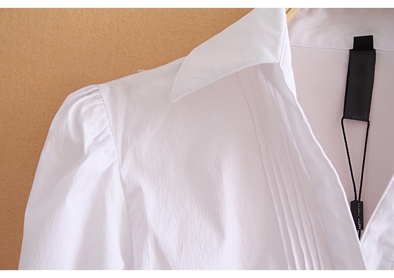 White bodysuit with long sleeves on a beige background