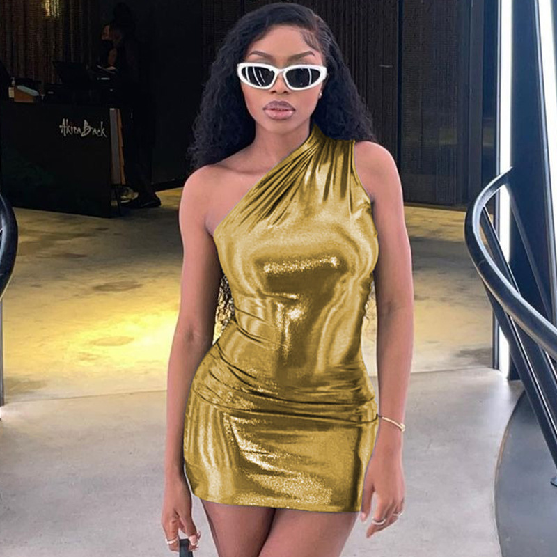 Woman wearing a Gold one-shoulder dress in an indoor setting.