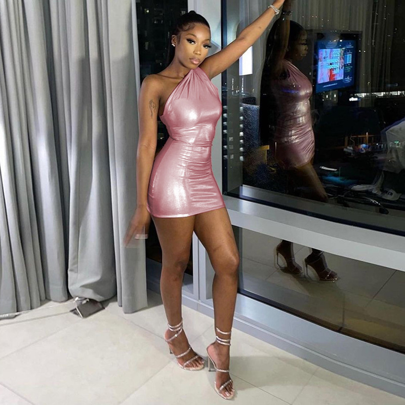 Woman wearing a pink one-shoulder dress in an indoor setting.
