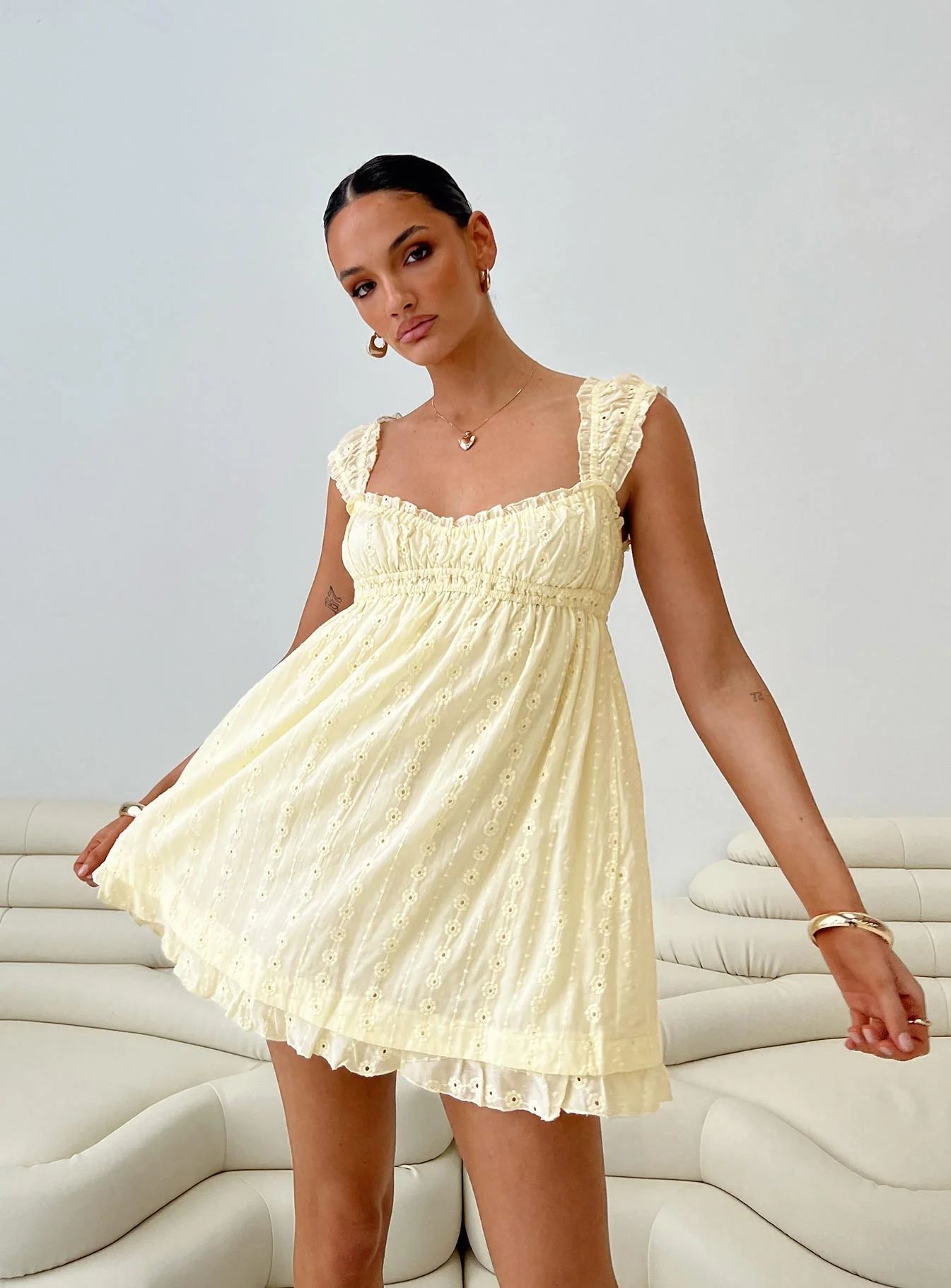 Woman wearing a light yellow dress on a white background