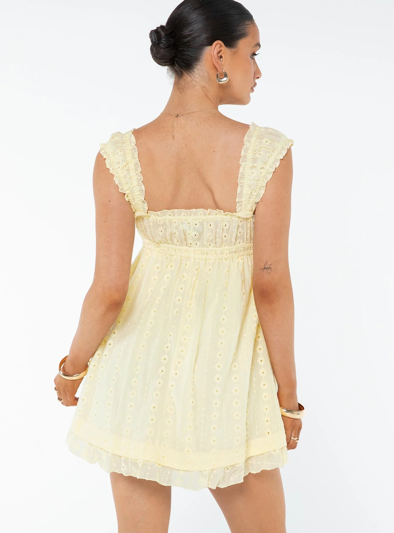 Woman wearing a light yellow dress on a white background