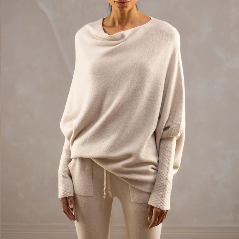 Person wearing a loose-fitting off-shoulder top and pants against a neutral background
