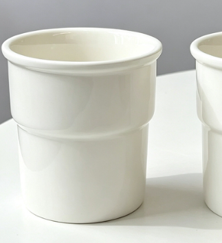Hand holding a white ceramic cup