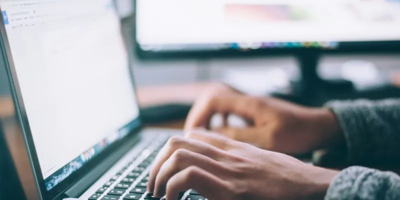 A man is typing on the keyboard to reply a message