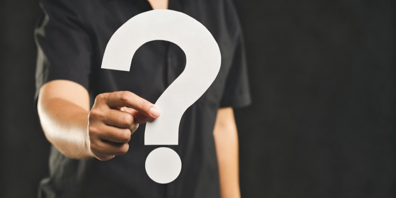 Person holding white question mark sign