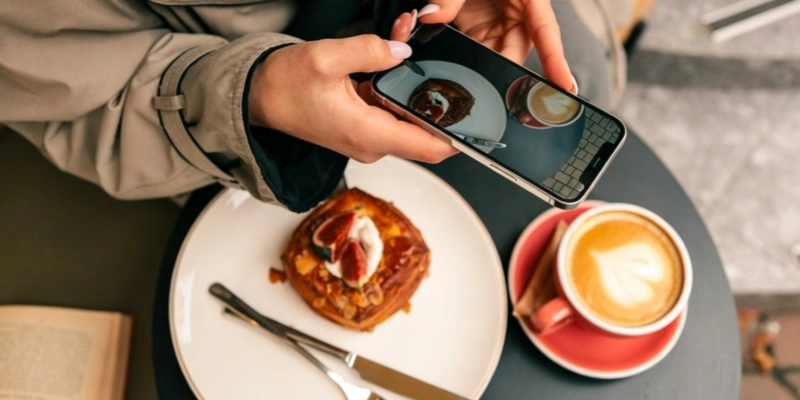 Social media content creator photographing pastry coffee